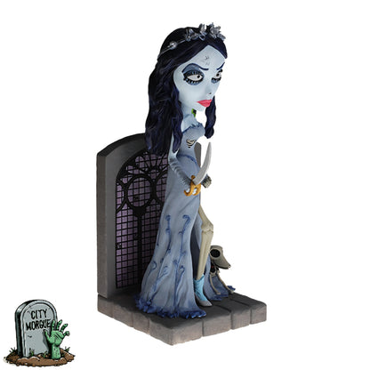 Royal Bobbles Emily bobblehead in a gray dress, holding scissors, with blue hair and a tombstone backdrop.